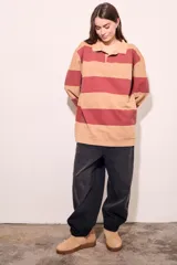 Sweater de algodón a rayas horizontales color crema y marrón, con cuello polo y mangas largas.