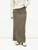 Falda larga color verde oliva, de corte recto y tiro alto, con presillas y cierre invisible lateral.