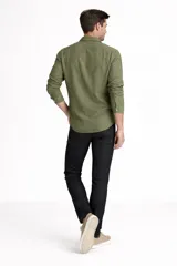 Camisa de manga larga color verde oliva, con cuello clásico, cierre frontal de botones y dos bolsillos frontales con solapa.