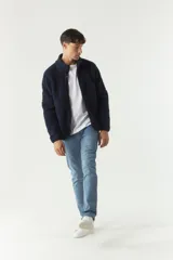 Campera de sherpa azul marino con cuello alto, cierre frontal completo y bolsillos laterales con cierre.