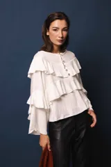 Blusa de lino color blanco, con silueta oversize, cuello bote y volados en el frente.