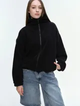 Campera de tela fleece doble, color negro, con cierre frontal completo, cuello alto y bolsillos laterales. Presenta puños y bajo elastizados para un ajuste cómodo.
