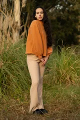 Buzo color naranja con cuello alto y mangas abullonadas.