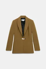 Blazer entallada color tostado con cuello solapa, manga larga y hombreras. Presenta cierre frontal con un botón metálico dorado y bolsillos delanteros de vivo.