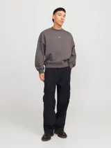 Pantalón cargo de corte amplio y tiro medio, confeccionado en sarga de algodón resistente. Presenta bolsillos laterales tipo cargo, bolsillos delanteros y traseros, cierre con cremallera y diseño de pierna ancha.