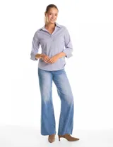 Camisa de algodón a rayas verticales azules y blancas, con cuello solapa y cierre frontal de botones decorados con strass. Presenta aplicaciones de strass en la parte superior delantera, pinzas de entalle y mangas tres cuartos.