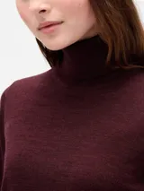 Buzo de punto con cuello alto tipo polera, de corte ajustado y manga larga.