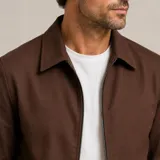Chaqueta de gabardina con elastano, de corte clásico con cuello camisero y cierre frontal completo.