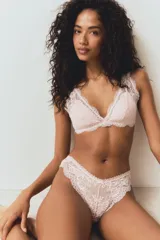 Pack de dos bombachas tipo brazilian de tiro bajo y corte alto en la parte trasera, confeccionadas completamente en encaje con diseño floral. Cuentan con cintura en V y un pequeño moño decorativo en el centro.