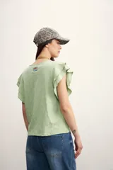 Remera color amarillo pastel con cuello redondo y mangas cortas con volados.