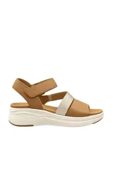 Sandalia plana color beige, con tiras en el empeine, una de ellas en tono metalizado, y tira ajustable con velcro en el talón. Cuenta con suela blanca con plataforma ligera.