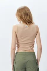 Top cropped color lila sin mangas y cuello a la base, con frunces en ambos laterales.