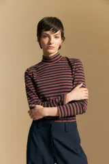 Polera de cuello alto y manga larga, confeccionada en tejido elástico con diseño de rayas horizontales en tonos azul marino y terracota.