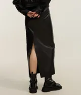 Pollera midi en poliuretano color negro, de corte recto y ajustado, con recortes frontales y abertura trasera.