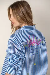 Camisa blanca de manga larga con bordados de motivos playeros.