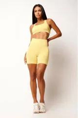 Short deportivo color amarillo, de tiro alto y corte ajustado. Confeccionado con tecnología seamless y textura acanalada en la cintura.
