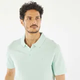 Chomba de piqué de algodón color verde claro, corte clásico, con cuello polo y tapeta de dos botones.