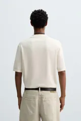 Polo de punto de corte regular fit, confeccionado en una mezcla de algodón y lyocell. Presenta cuello de solapa con cierre frontal de botones, manga corta y acabados en rib en puños y bajo.