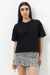 Remera negra de algodón, de corte recto y mangas cortas con dobladillo.