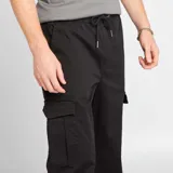 Pantalón jogger negro con bolsillos cargo con solapa, corte slim y puños elásticos.