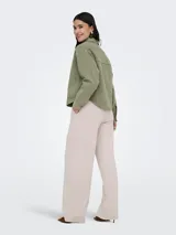 Sobrecamisa de jean de color negro gastado, con cuello camisero, cierre frontal de botones metálicos, bolsillos frontales de parche y mangas largas.