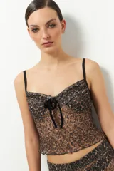 Top negro de encaje sin mangas con lazo de terciopelo en el centro del busto.