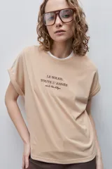 Remera blanca de silueta amplia y calce relajado, confeccionada en tela suave y liviana, con cuello redondo, mangas cortas con vuelta y hombros caídos. Cuenta con un delicado bordado frontal en color azul con la inscripción "LE SOLEIL TOUTE L'ANNÉE sur la Côte d'Azur".