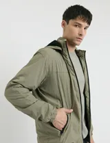 Campera negra con capucha, cierre frontal completo y bolsillos laterales con cierre. Diseño ligero con puños elásticos.