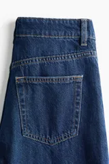 Pantalón jean wide leg de tiro extra alto, color azul oscuro, confeccionado en denim de algodón rígido, con diseño de cinco bolsillos y perneras amplias.