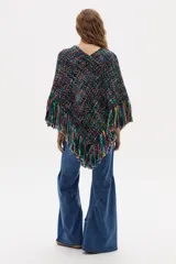 Poncho tejido en lana merino multicolor con escote en V y flecos decorativos en el ruedo.