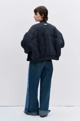 Cazadora tipo bomber de color negro con diseño acolchado de rombos, cuello, puños y ruedo acanalados, cierre frontal y bolsillos laterales.