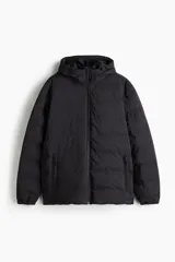 Campera puffer negra repelente al agua, con diseño guateado, cuello elevado, capucha con cordón ajustable, cierre frontal y bolsillos laterales con cierre.