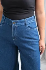 Jean de corte recto y tiro alto, confeccionado en denim azul clásico con costuras en hilo blanco a contraste. Presenta cierre frontal con botón metálico y bolsillos laterales.