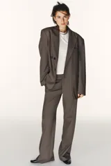 Blazer oversize de Zara con diseño a rayas verticales, cuello con solapa de muesca y hombreras. Presenta un cierre frontal cruzado con doble botonadura, bolsillos delanteros con solapa y un bolsillo de vivo en el pecho. Incluye forro interior a tono.