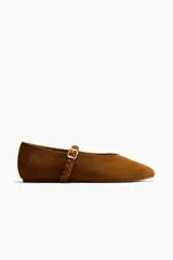 Ballerinas de gamuza color marrón con punta redondeada y tira trenzada ajustable en el empeine con hebilla metálica.