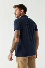 Remera con cuello polo en tejido buttoné, corte regular, logo bordado y mangas cortas.