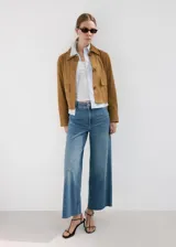 Jeans de tiro medio en tono azul clásico, de corte wide leg y diseño holgado con bajo deshilachado.