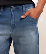 Bermuda slim de jean color azul gastado, con bolsillos laterales y traseros, cierre frontal con botón y bragueta, y diseño de dobladillos.