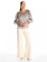 Blusa de organza translúcida con acabado satinado, mangas estilo balloon con volados en los hombros y puños elastizados. Incluye musculosa interna a tono.