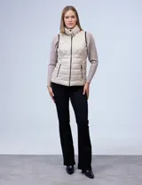 Chaleco capitoneado color rosa claro, con cuello alto, cierre frontal y bolsillos laterales.