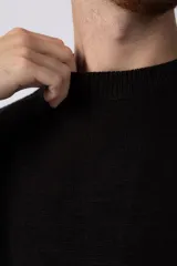 Sweater de punto grueso en color verde oliva, con diseño oversized, cuello redondo y mangas largas con puños acanalados.