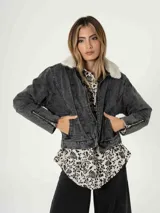 Campera de jean color gris oscuro, con cuello de corderito blanco, cierre frontal, bolsillos laterales y cierres decorativos en las mangas.