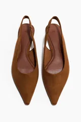 Zapatos destalonados de punta fina confeccionados en gamuza color marrón, con tira elástica en el talón.