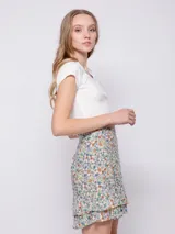 Minifalda verde con estampado de flores blancas y volados en el ruedo.