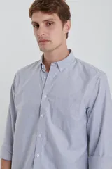 Camisa gris de algodón Oxford, manga larga con puños abotonados y cuello button-down. Tiene un bolsillo de parche en el pecho.