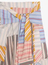 Falda larga cruzada de viscosa y poliamida, color celeste con estampado de líneas diagonales bordó. Presenta silueta amplia, bolsillos laterales y detalle de mangas de camisa incorporadas en la cintura para anudar.