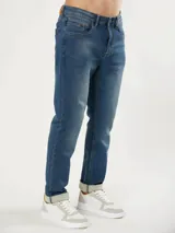 Jean de corte slim fit con cintura media y cierre frontal con botón y cremallera. Presenta un lavado azul clásico con costuras en contraste.