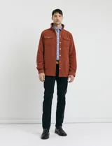 Pantalon de pana de corte recto con diseño de cinco bolsillos, incluyendo bolsillos traseros de parche y cierre con botones y remaches metálicos.