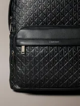 Mochila Calvin Klein negra de poliuretano, con diseño de monograma grabado en relieve, compartimento principal con cierre superior, bolsillo delantero con cremallera, asa de mano superior y tirantes ajustables.
