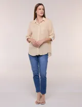 Camisa de rayas finas verticales en tonos amarillo y blanco, de corte clásico y silueta holgada. Cuenta con cuello camisero, cartera frontal de botones, un bolsillo plaqué en el pecho con rayas horizontales a contraste, mangas largas con presilla y ruedo curvo.